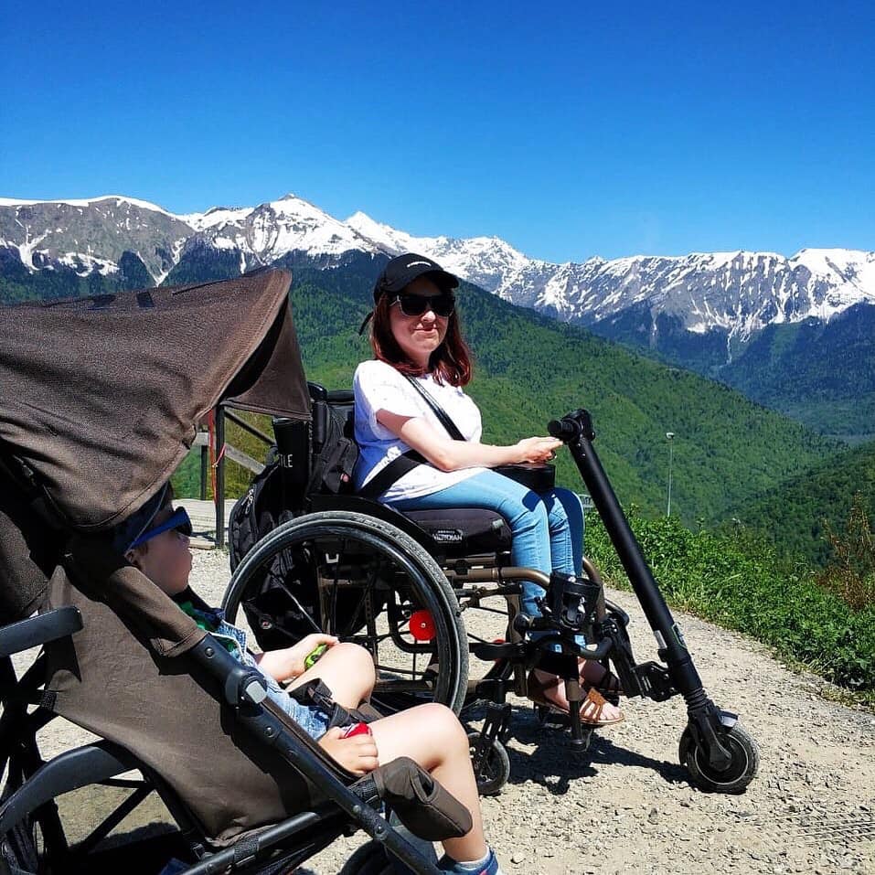 wheelchair user with UNAwheel and mountain backdrop